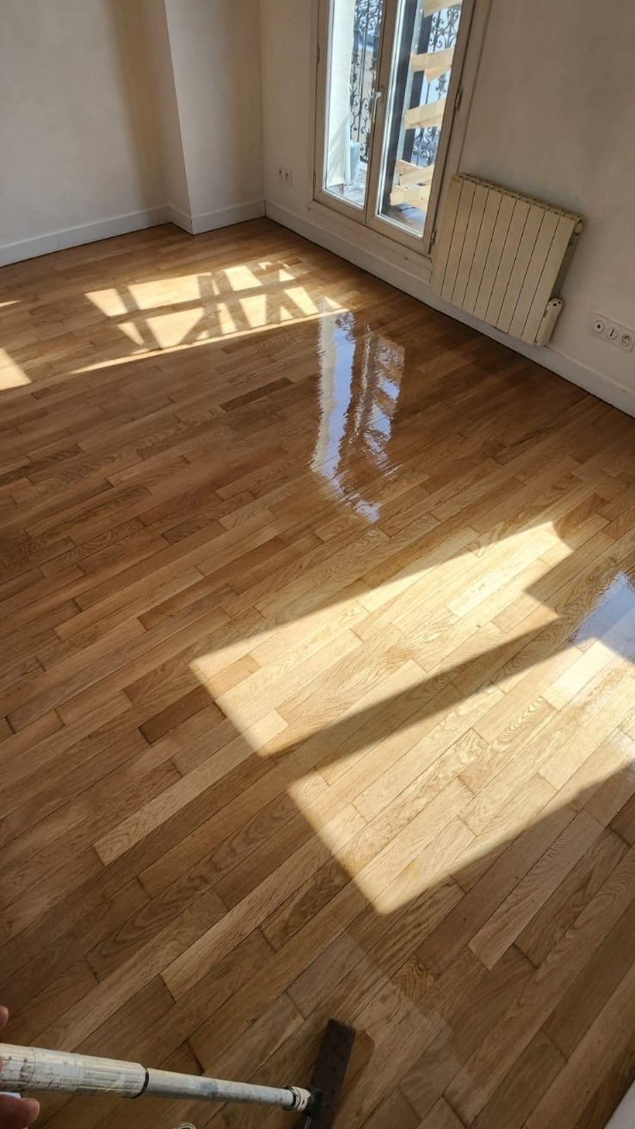 Le même parquet poncé et vitrifié, en cours de nettoyage final