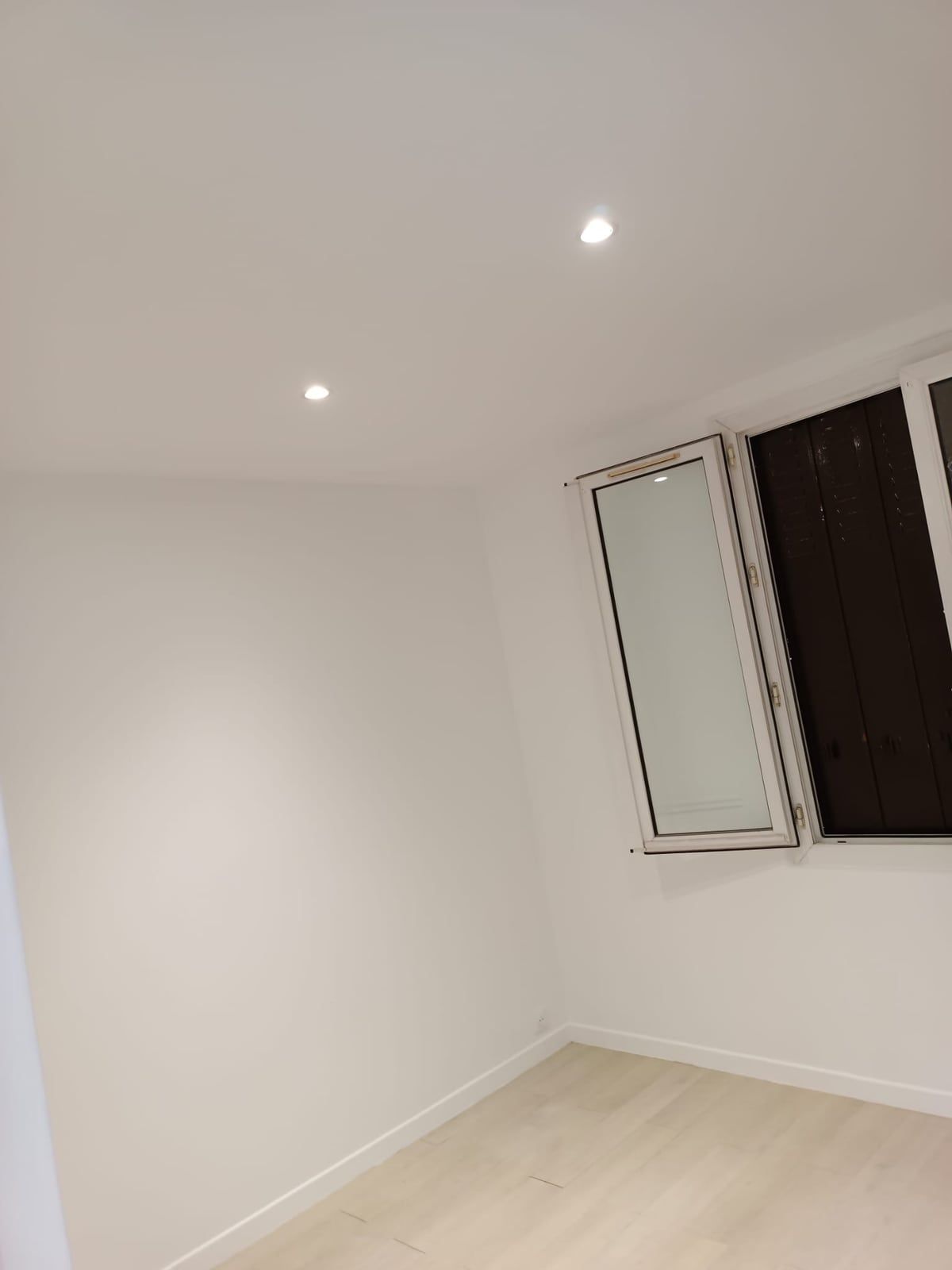 La même pièce livrée : plafond blanc avec spots encastrés, murs peints, sol clair et plinthes neuves