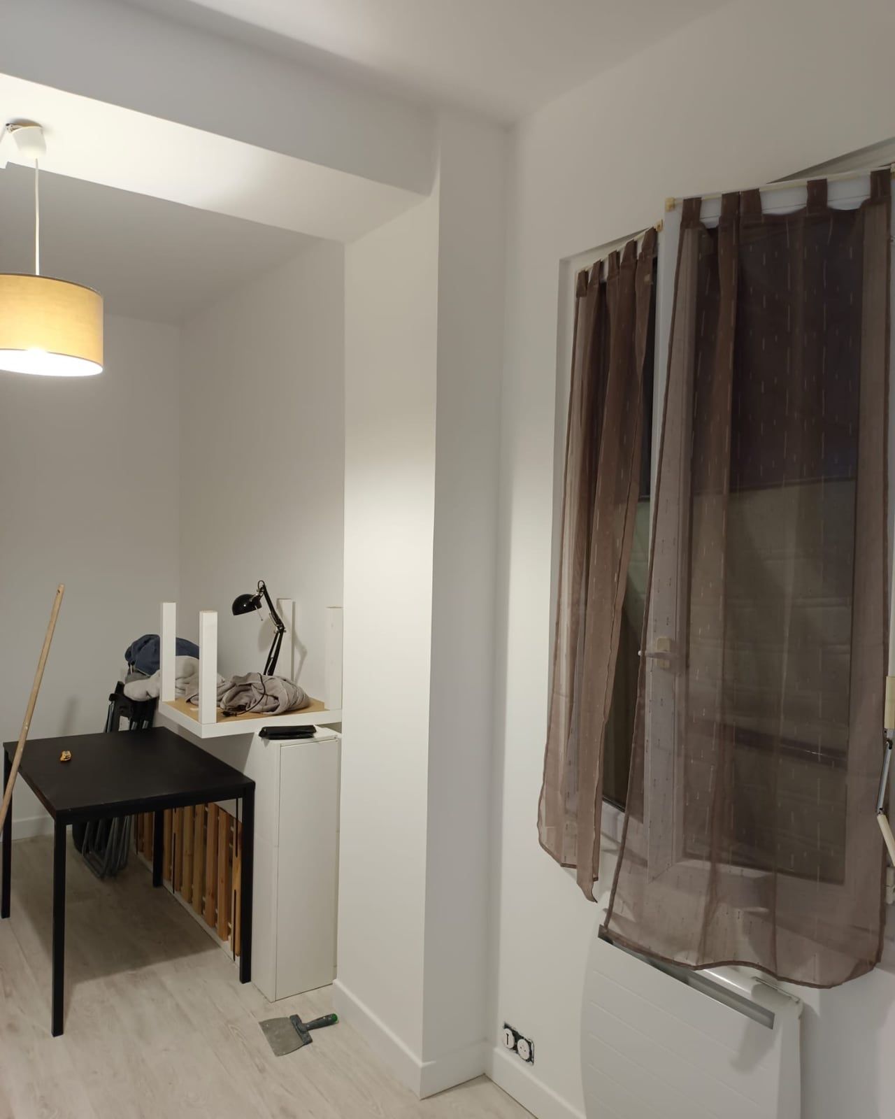 La même pièce terminée : murs peints, suspension posée, rideaux installés