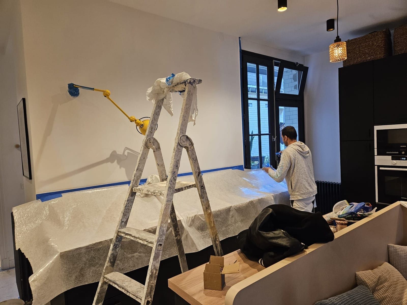 Mur d'un séjour fraîchement peint en blanc mat, coupe nette au niveau de la plinthe